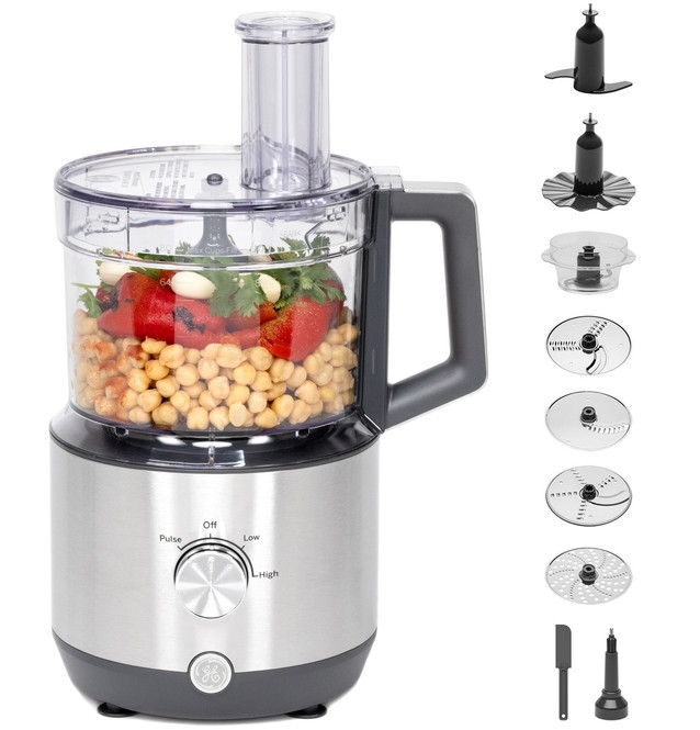 Food processor with ingredients and various attachments displayed beside it.