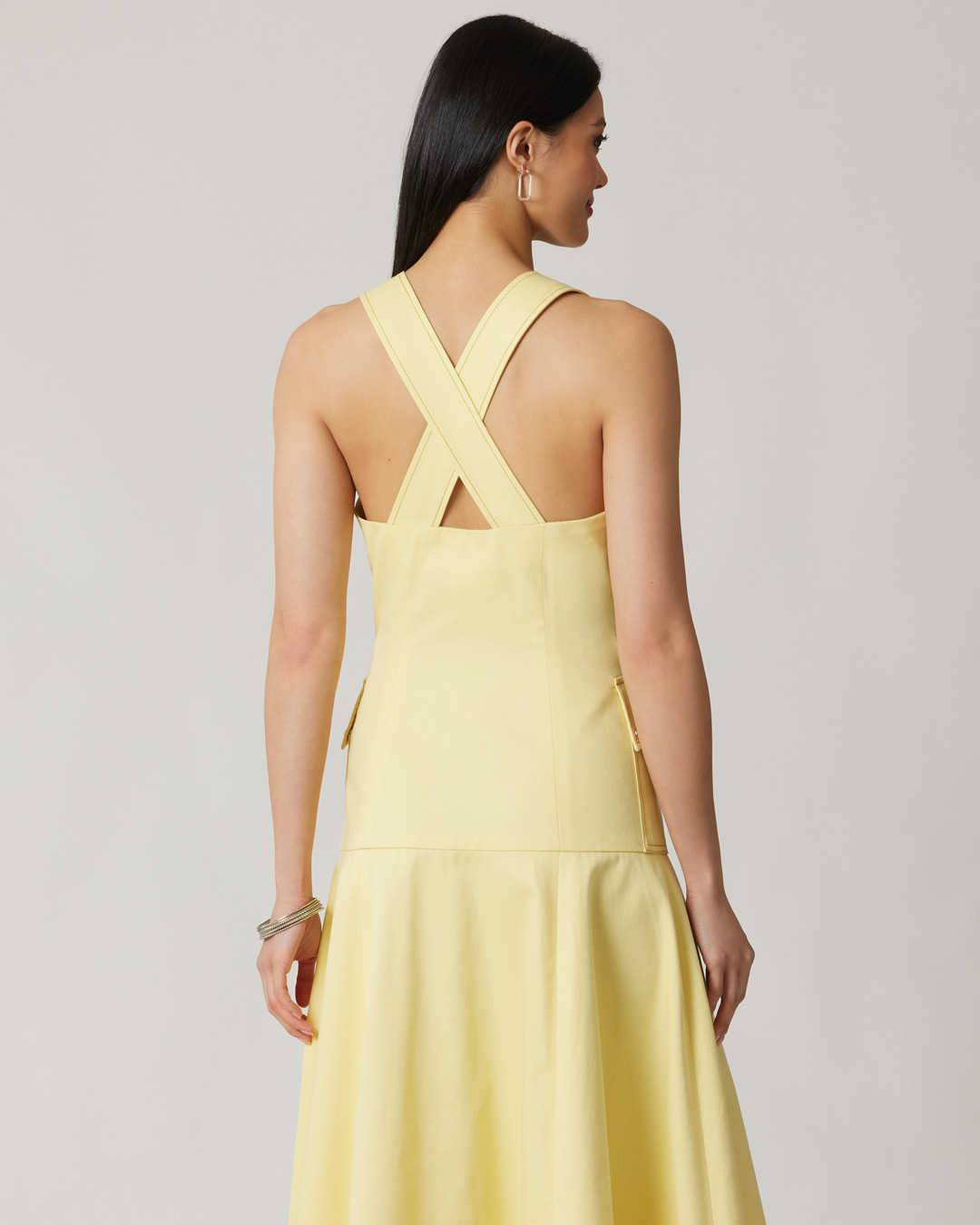 A woman wearing a yellow dress, viewed from the back.