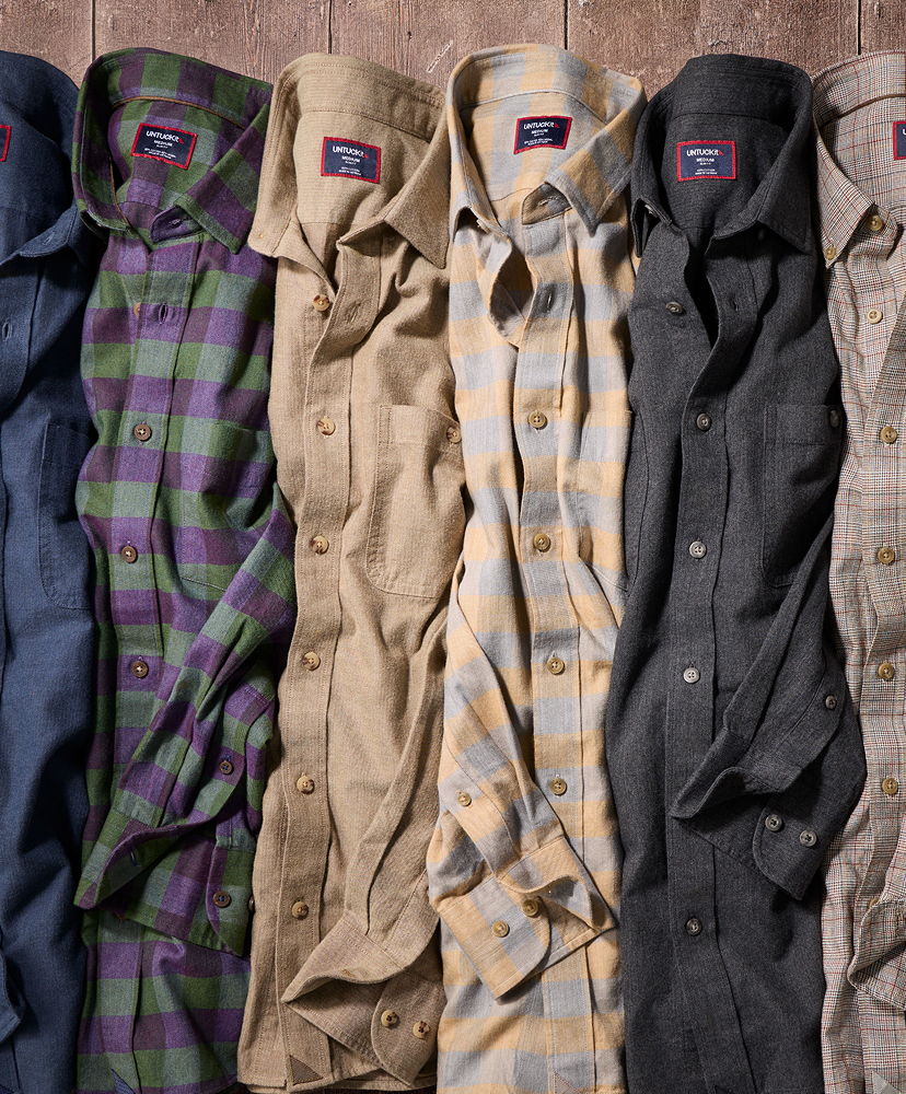 A row of various colored button-up shirts laid flat.