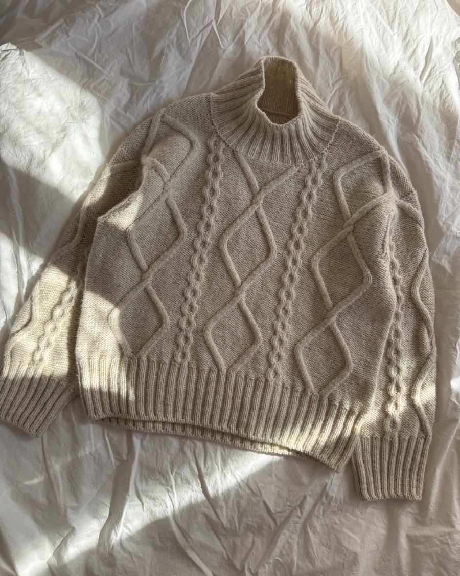 Hvid Saga Sweater liggende i solskin