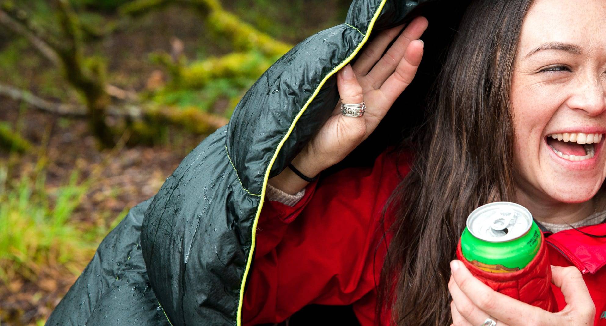 Girl hiding under Rumpl blanket from rain