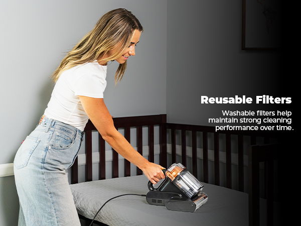 A woman cleans a crib with a vacuum. Text about reusable filters.