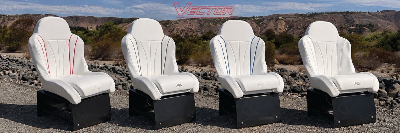 Four white chairs arranged on a rocky outdoor surface.