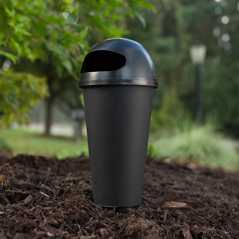 Small black outdoor mosquito trap placed in mulched bed