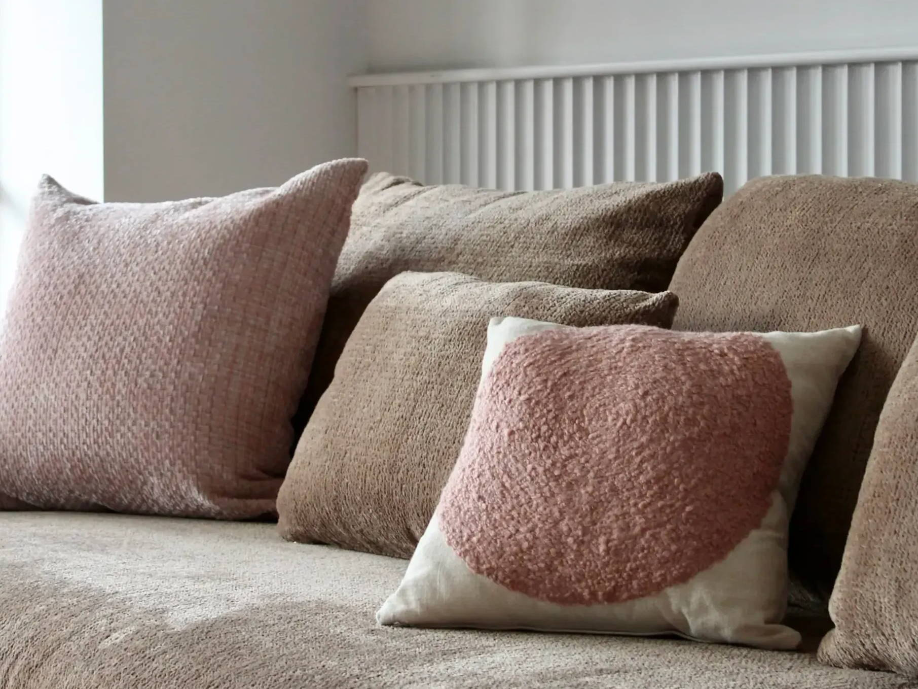 Pale pink and brown cushions on sofa.