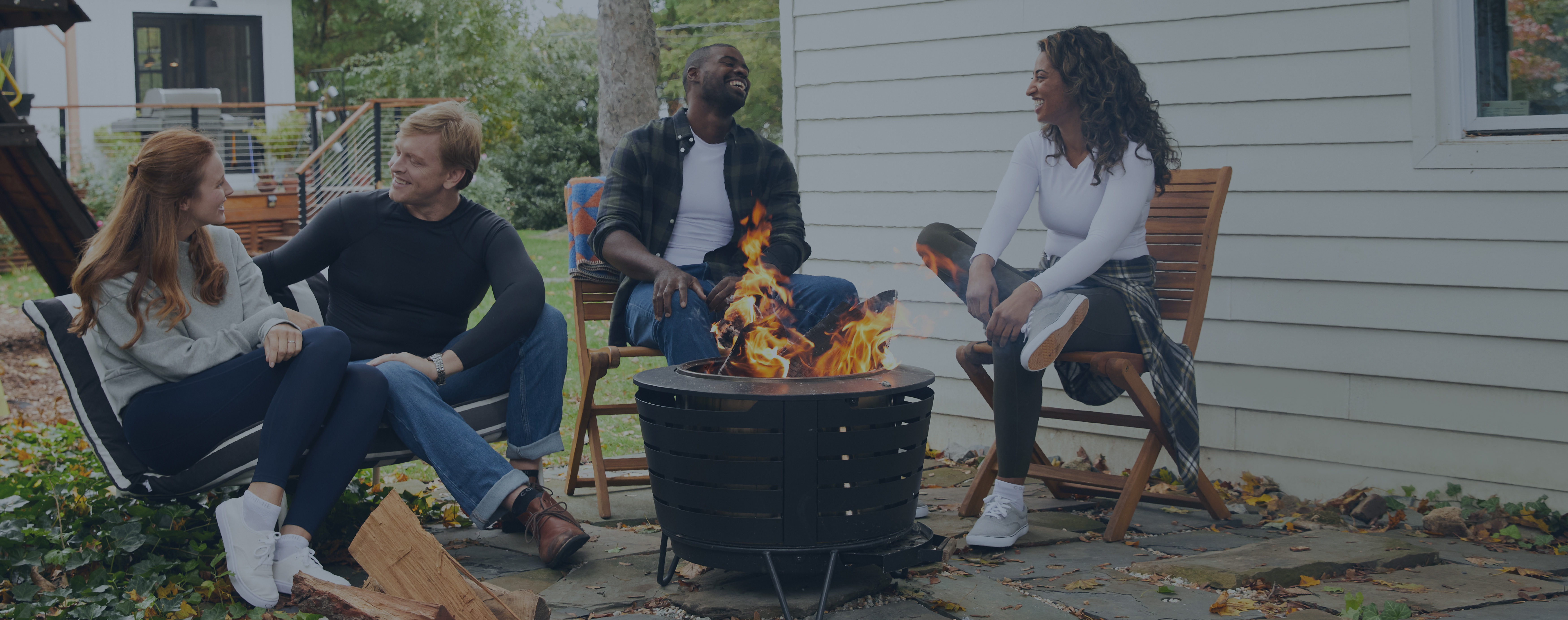 Group of people sitting around a fire pit wearing Tommie Copper Support Shirts.