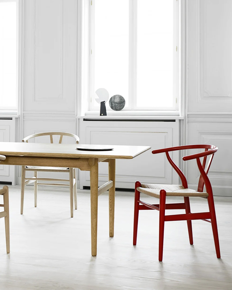 Wooden chair CH24 Dining Chair with a curved back and black seat, viewed from the back.