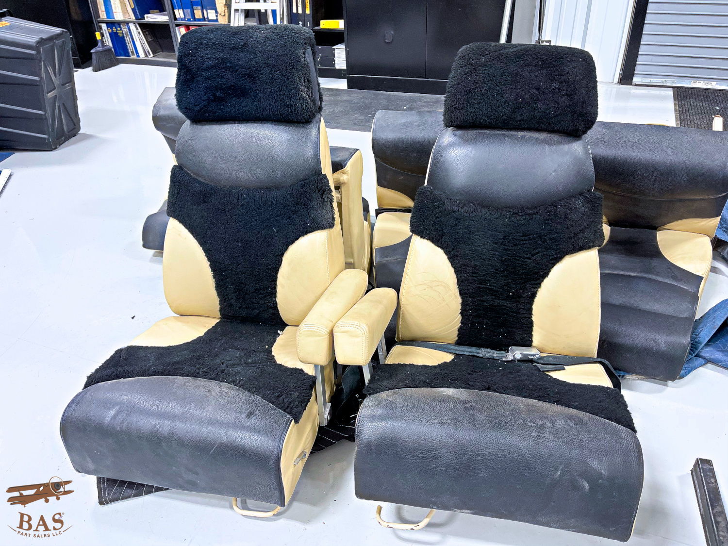 Two automotive seats with black and tan upholstery.