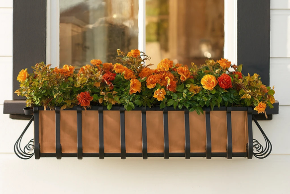 Colorful flowers in a window box under a sunny window.