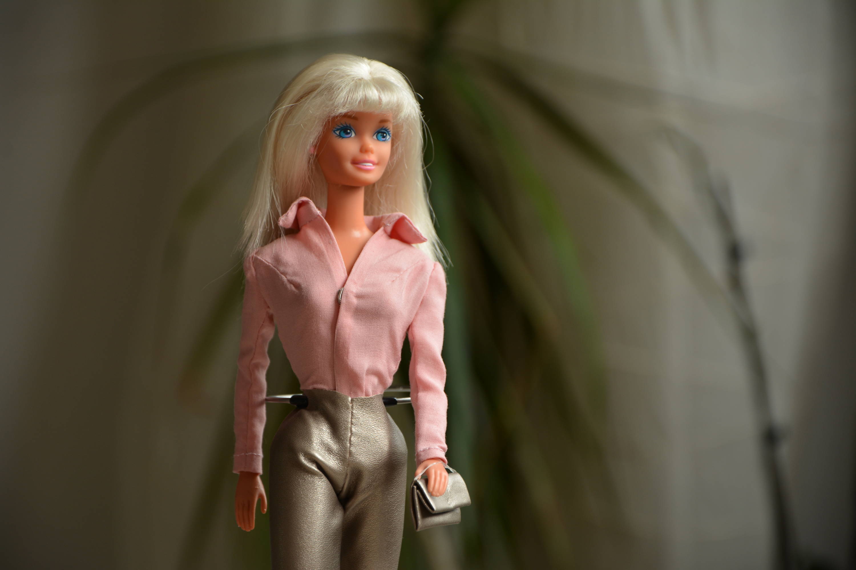 Barbie con top rosa y pantalón gris.