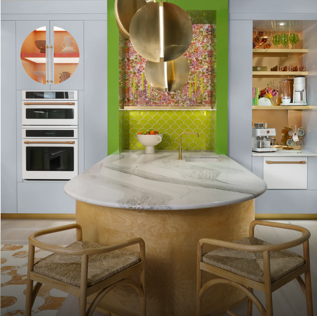 Modern kitchen with circular island, stylish decor, and colorful accents.