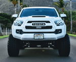 Head-on lifted white Toyota Tacoma black mesh grille halo rings CRUSE7 off-road tires palms Christian's Conductor's Special 232 gallery photo 3