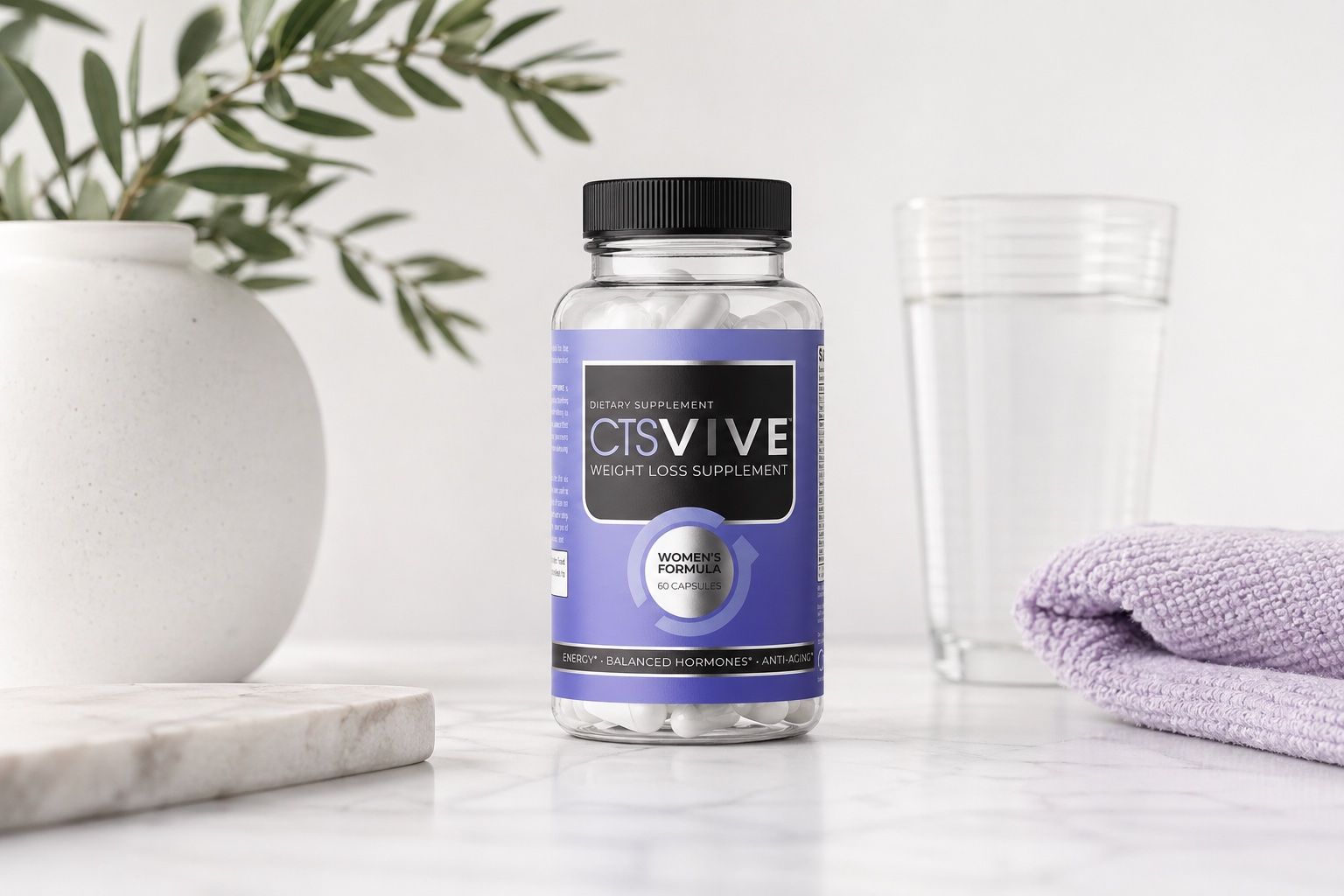 Bottle of womens metabolism booster on a marble surface with a glass of water.