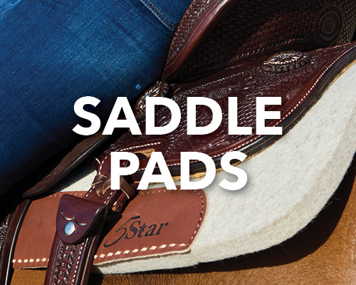 Saddle pads on a horse saddle with denim jeans in the background.