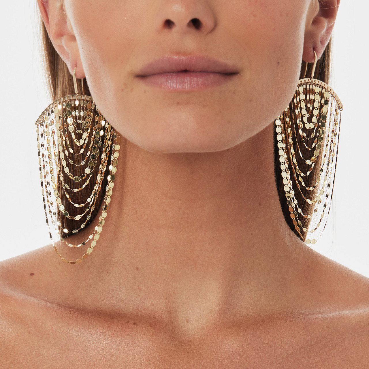 Close-up of a woman wearing large, sparkling chandelier earrings.