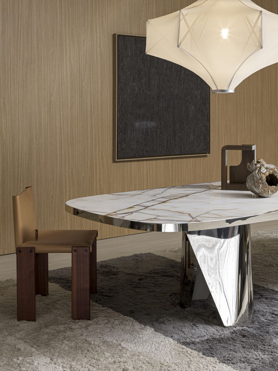 Molteni Marble table with brown veining beside a modern leather chair on a rug.