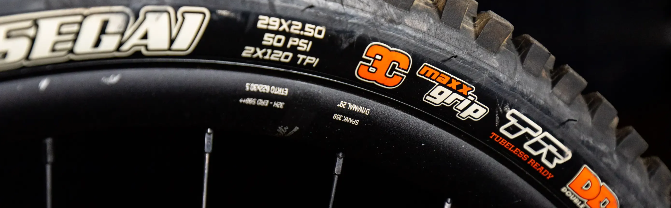 Detail of Maxxis Assegai Mountain Bike Tire with 3C Maxx Grip rubber compound on a black background