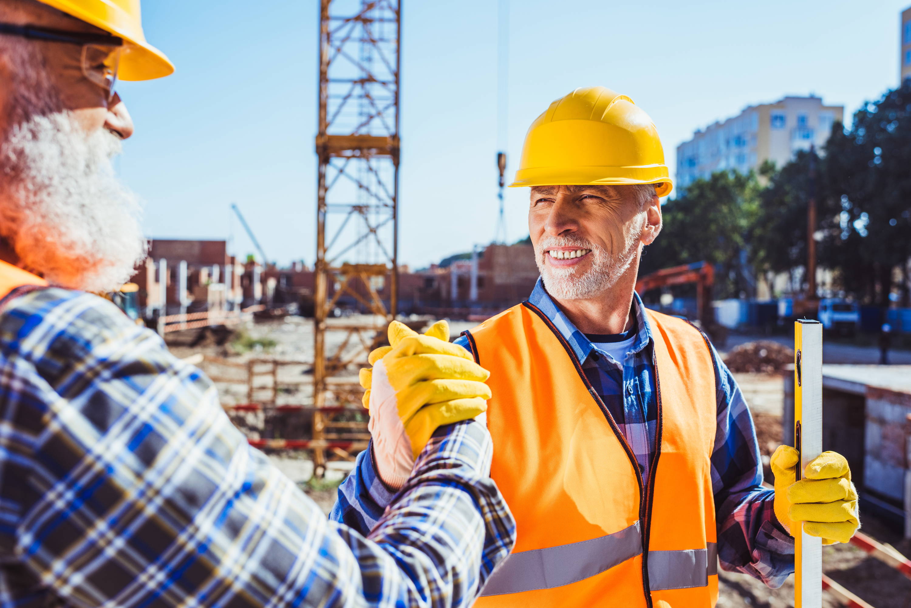 construction workers shaking hands and smiling
