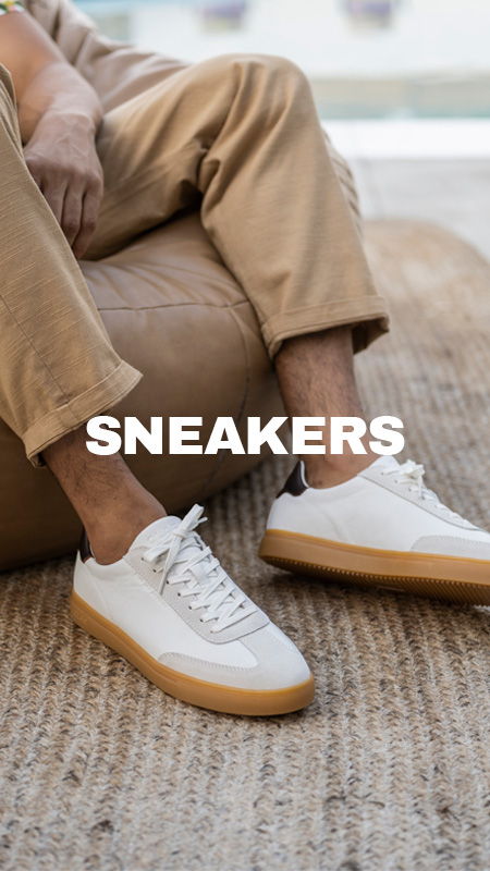Person wearing white sneakers sitting on a bean bag.