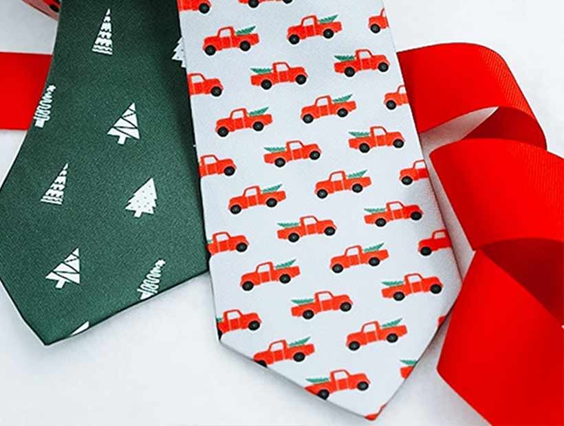 Christmas themed ties in pickup truck and tree patterns with a red ribbon
