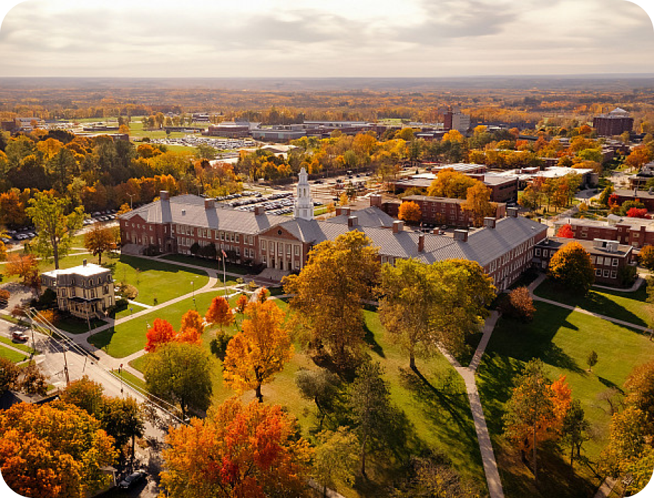 Aerial view of a campus surrounded by autumn foliage.