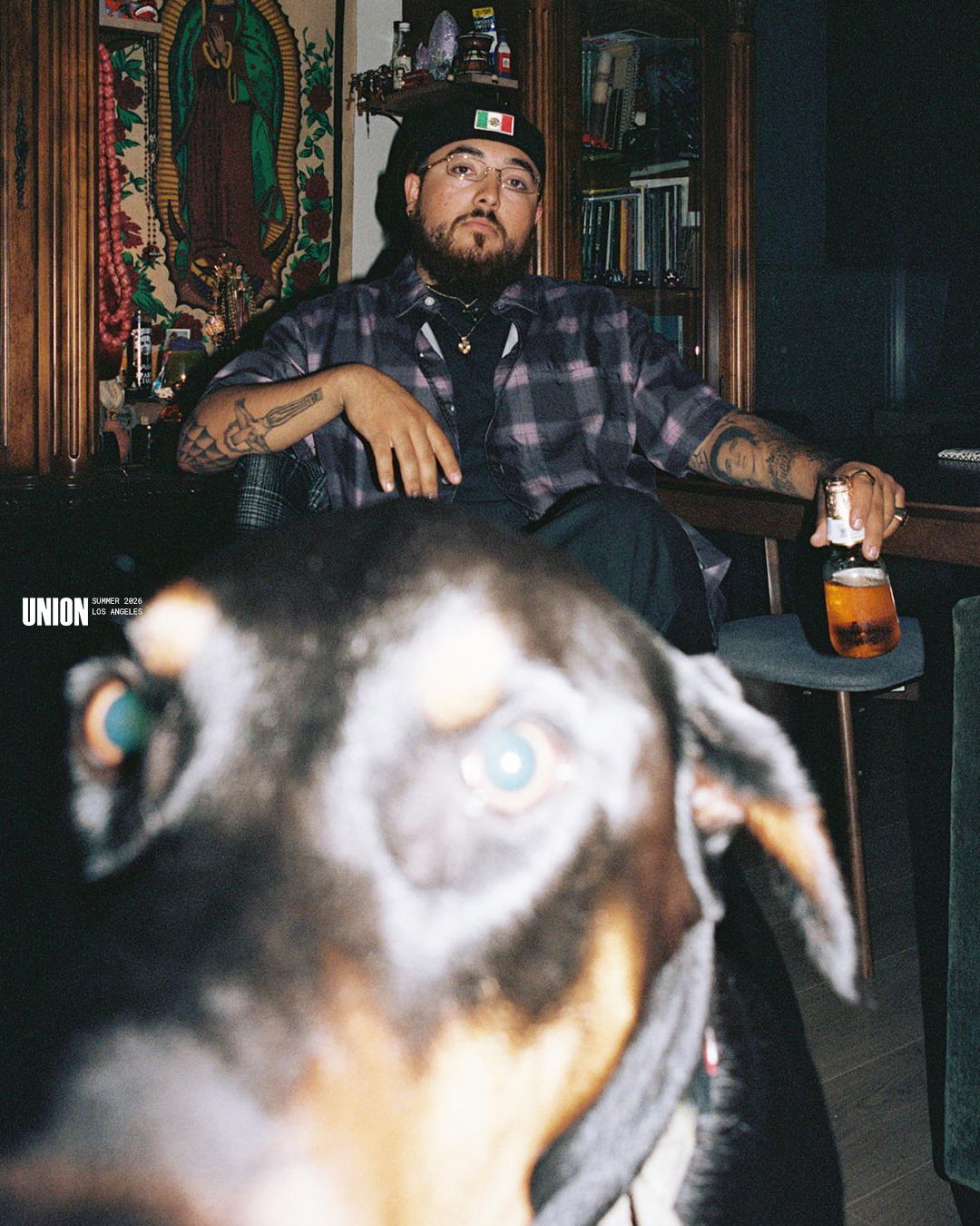 Man sitting indoors with a dog in the foreground.