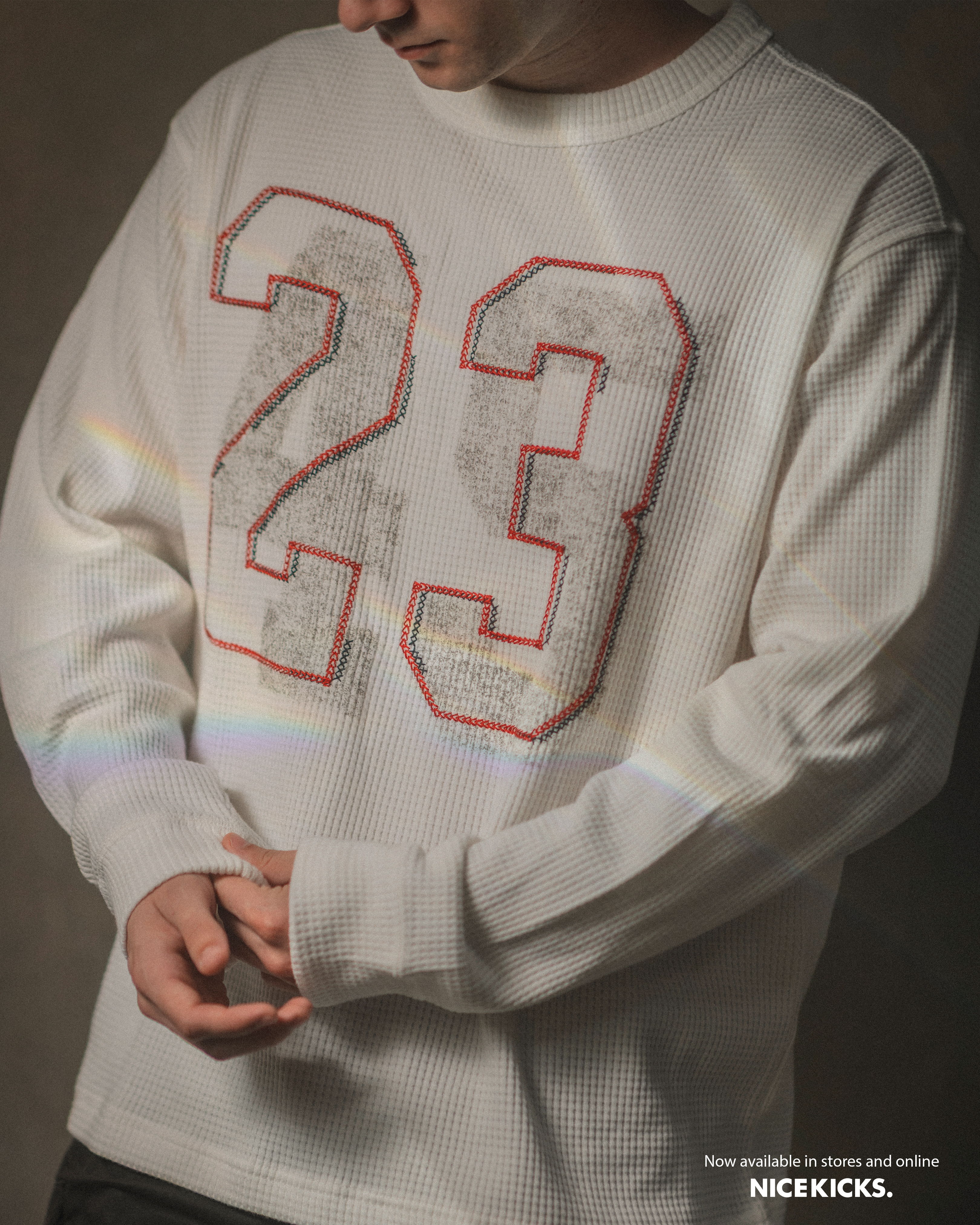 Person wearing a white sweatshirt with the number 23 on it.