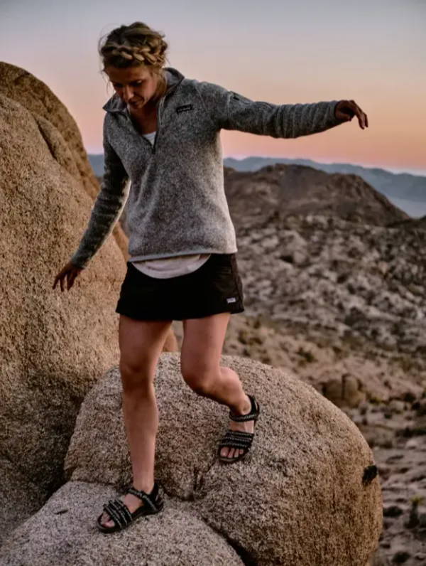 woman climbing rocks in water shoes