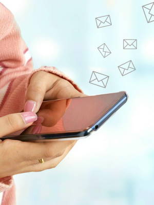 woman holding phone with email icons