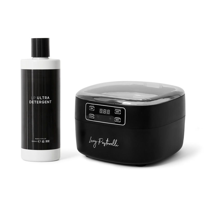 Black cleaning device with a bottle of cleaner beside it.