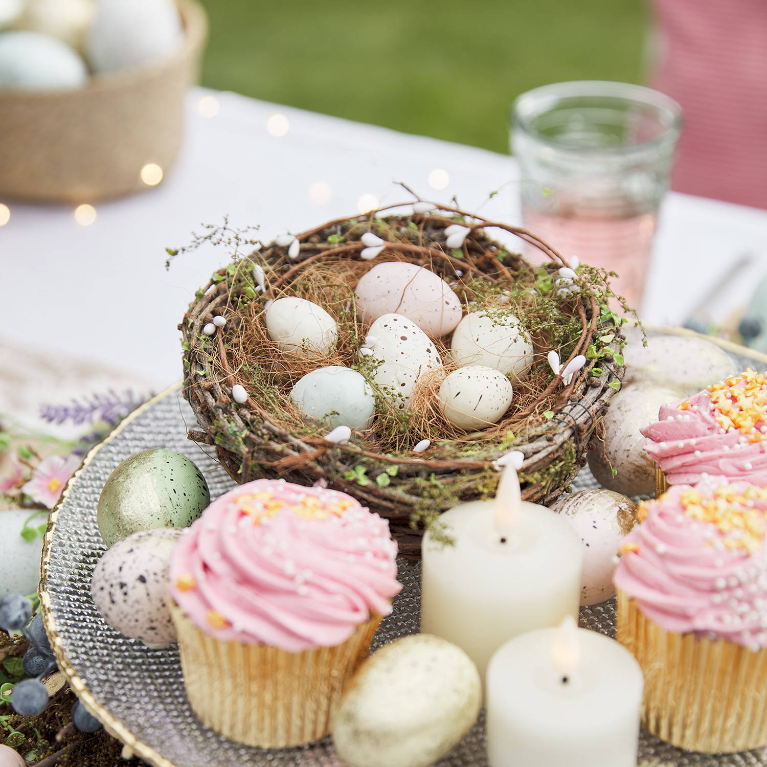 Easter next and egg decoration with LED votive candles, mini eggs and cupcakes as part of an Easter display.
