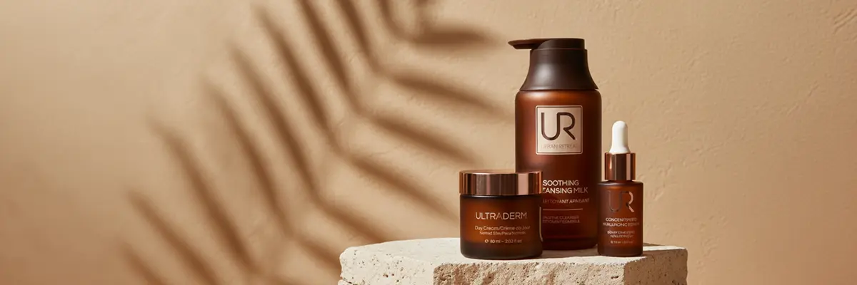 Three Urban Retreat skincare products displayed on a pedestal with a soft shadow background.