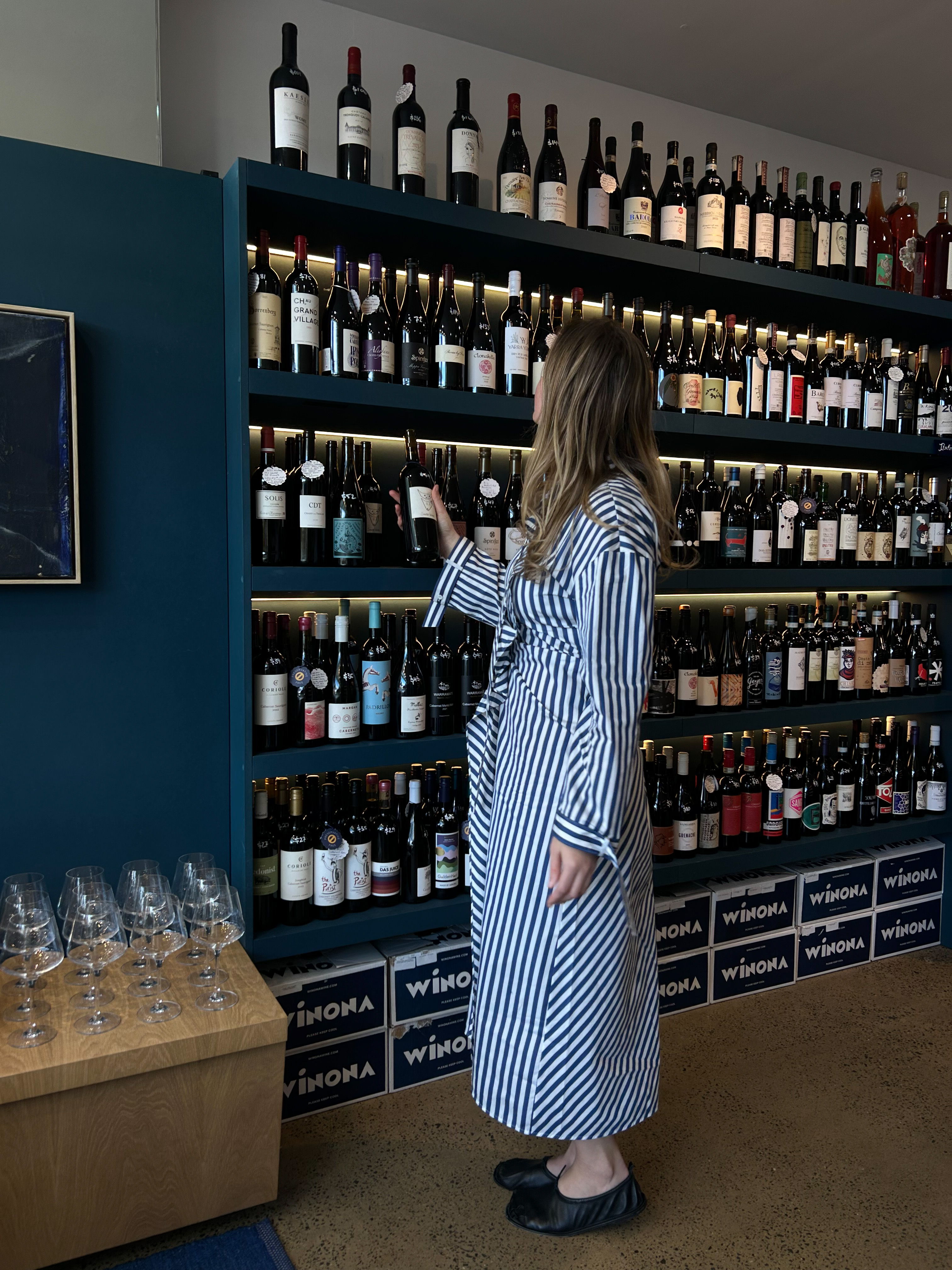 Bottles of wine at Winona Wine in Avalon, Charlotte wears the Josie Dress.