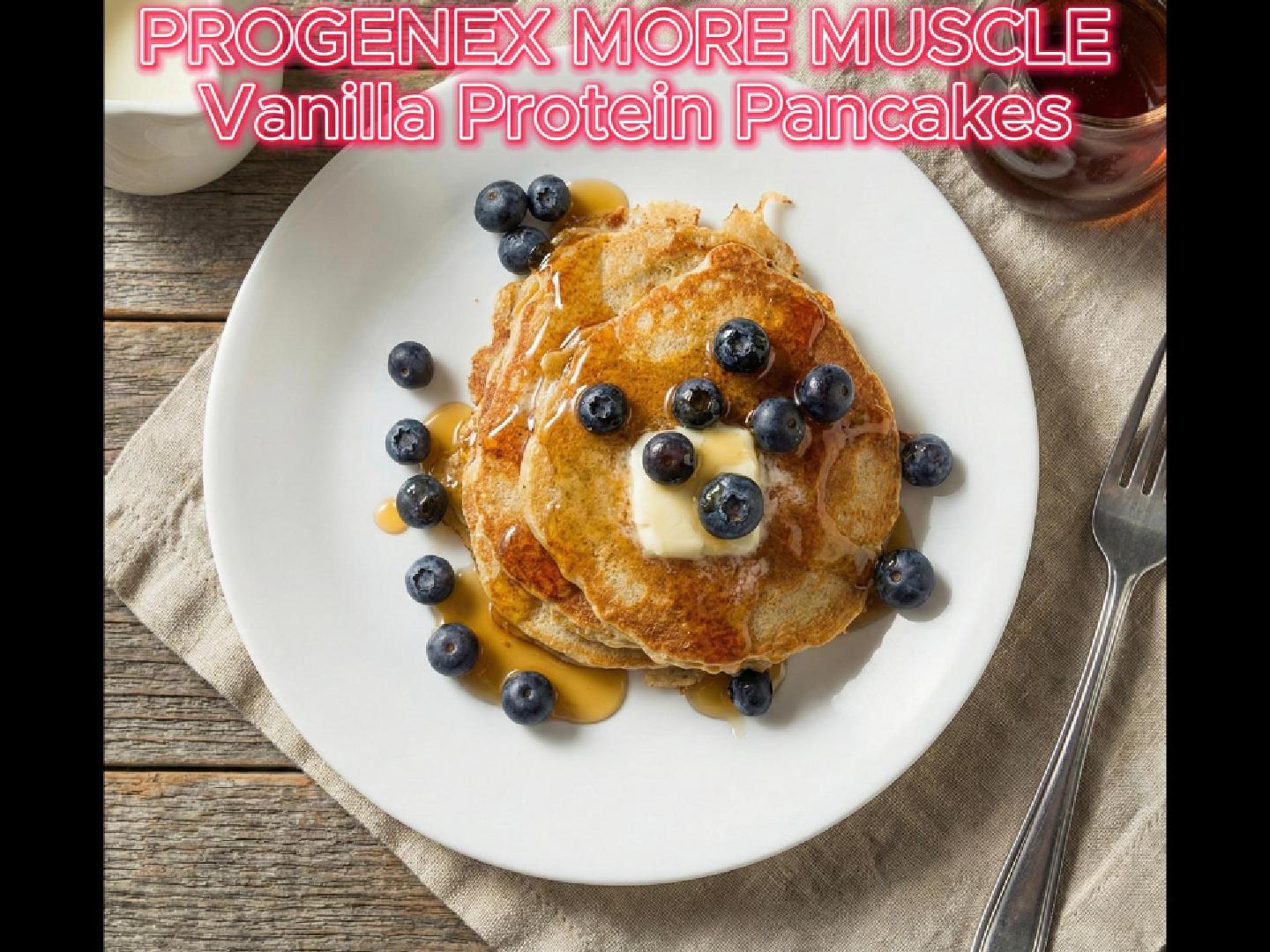 Vanilla protein pancakes topped with blueberries and syrup on a white plate.