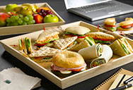 A wood tray with food inside