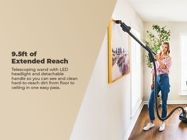 Person using a vacuum with a long reach in a bright room.