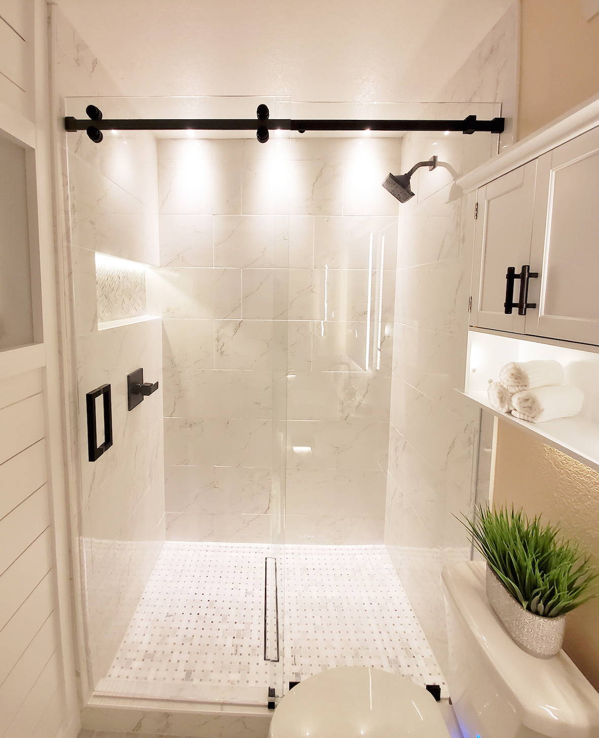 Beautiful bright bathroom lighting design in shower niches and cupboards
