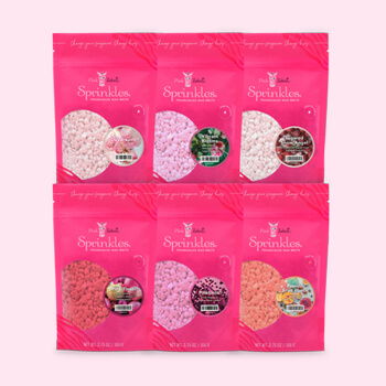 Six packages of heart-shaped bath salts in pink packaging.