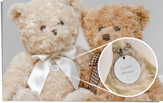  two teddy bears wearing a necklace engraved with an inscription