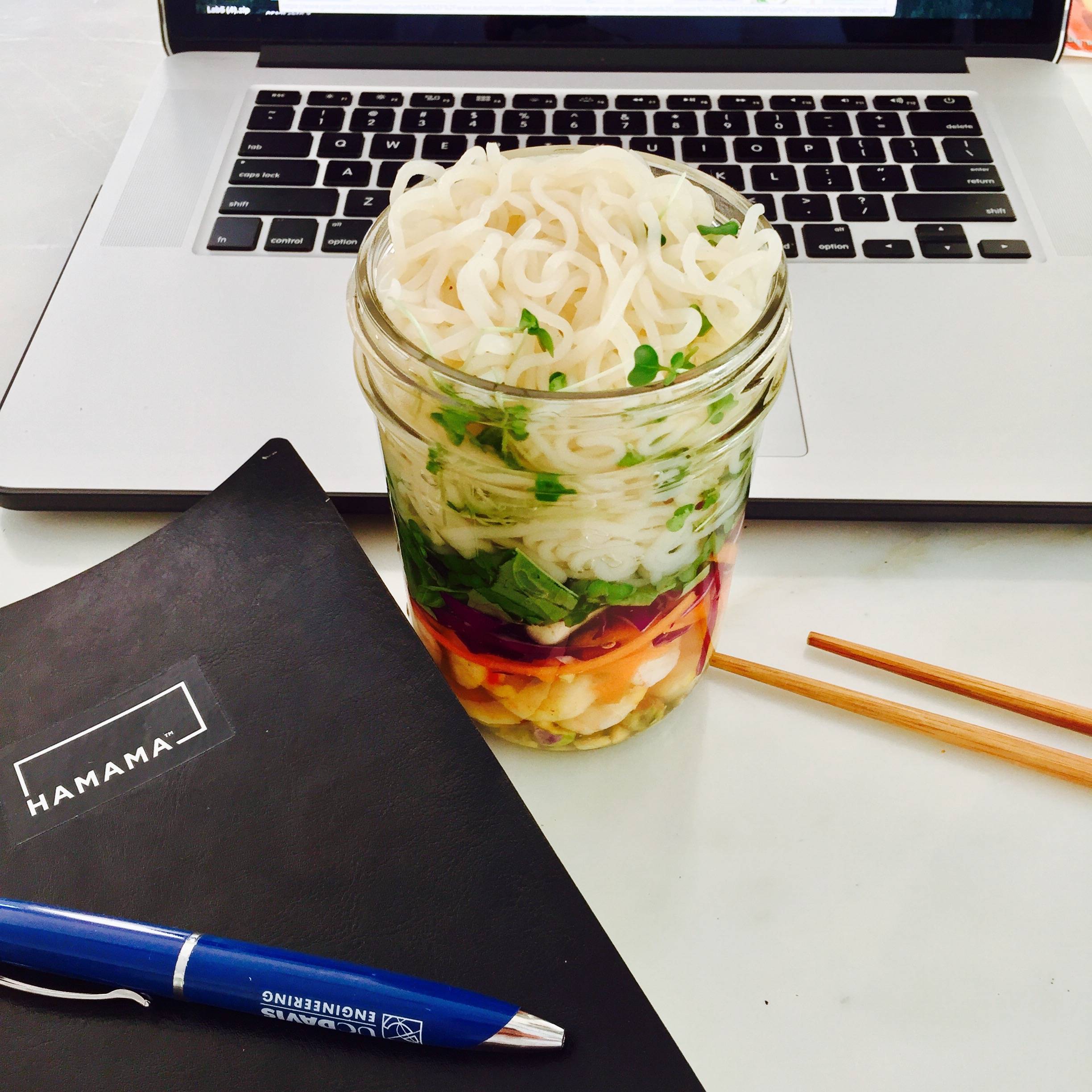 Pho in a mason jar with rice noodles, carrots, pistachios, purple cabbage, basil, and broccoli microgreens. 