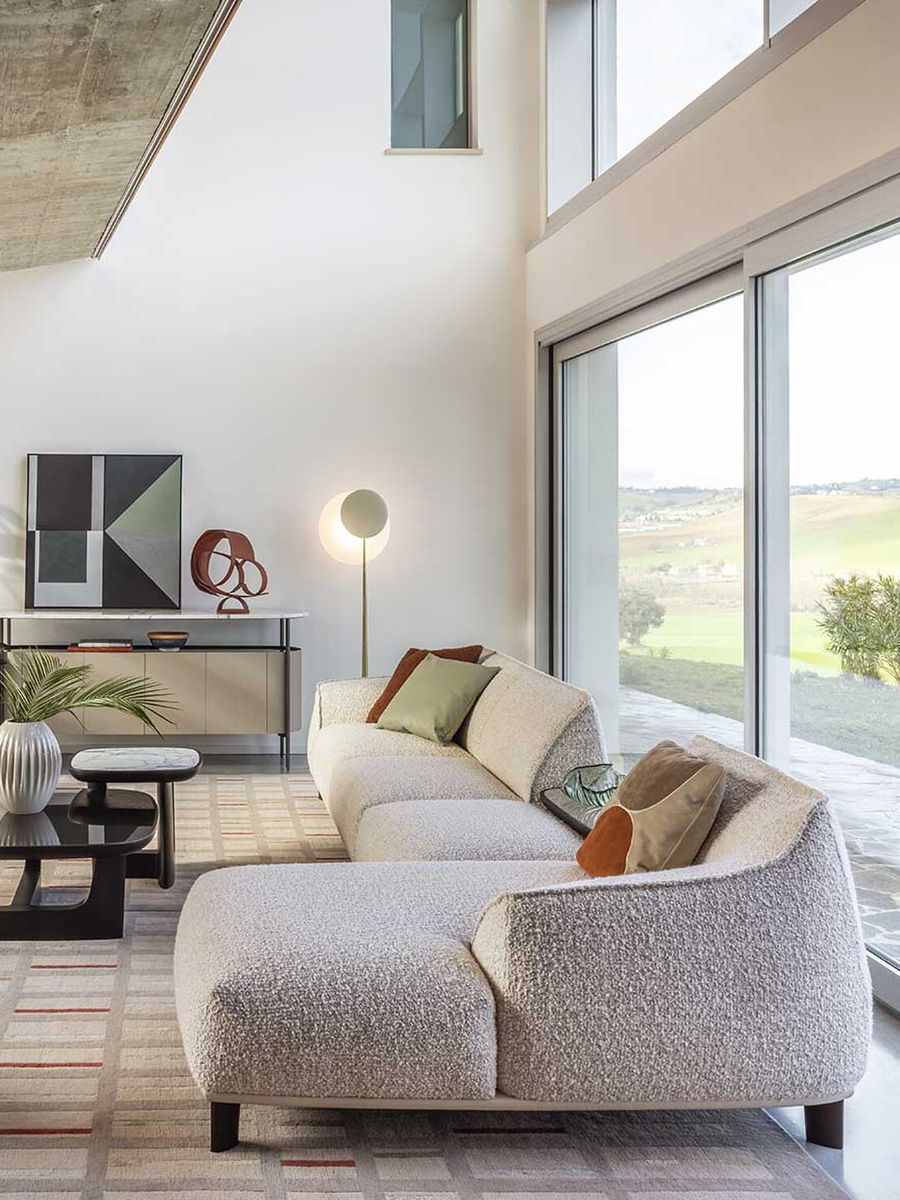 Modern living room with a an Archibald modular sofa, artwork, and large windows.