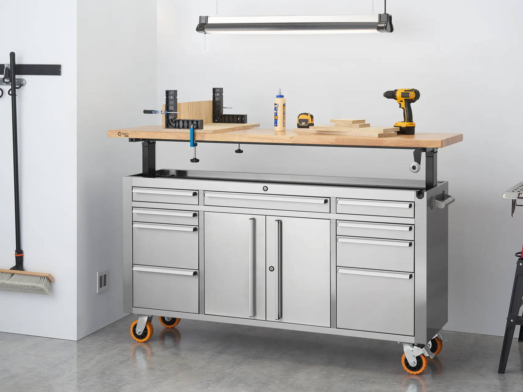 trinity stainless steel workbench with adjustable wood top in a garage