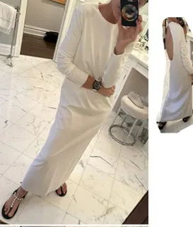 Person taking a mirror selfie in a long white dress and sandals.