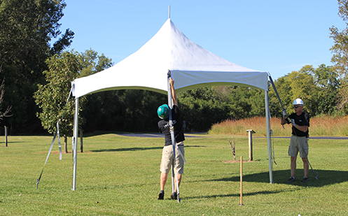 men installing ratchet assemblies on tent
