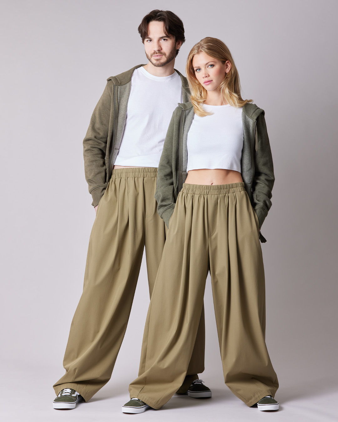 Two models wearing casual outfits with oversized pants and hoodies.