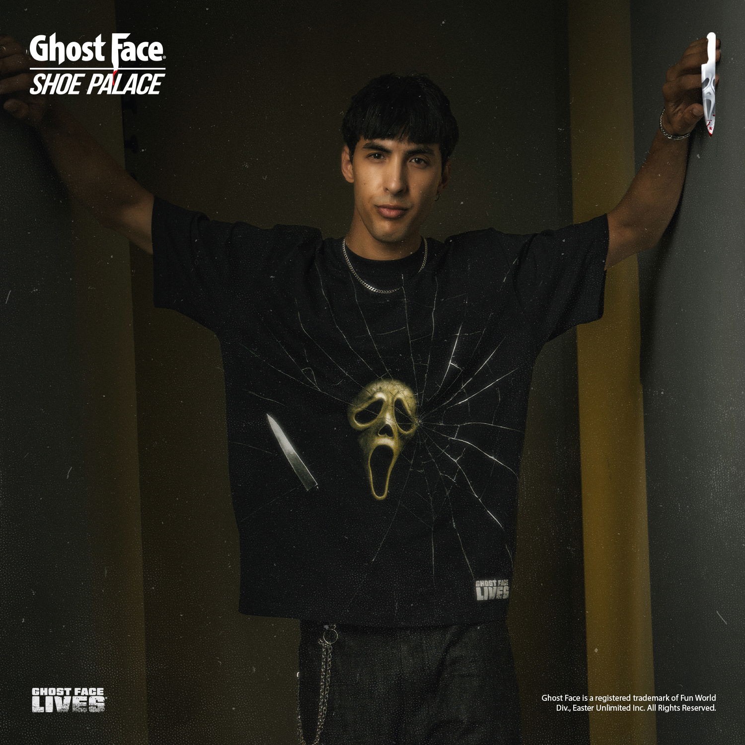 Person wearing a black shirt with a Ghost Face design, standing against a wall.