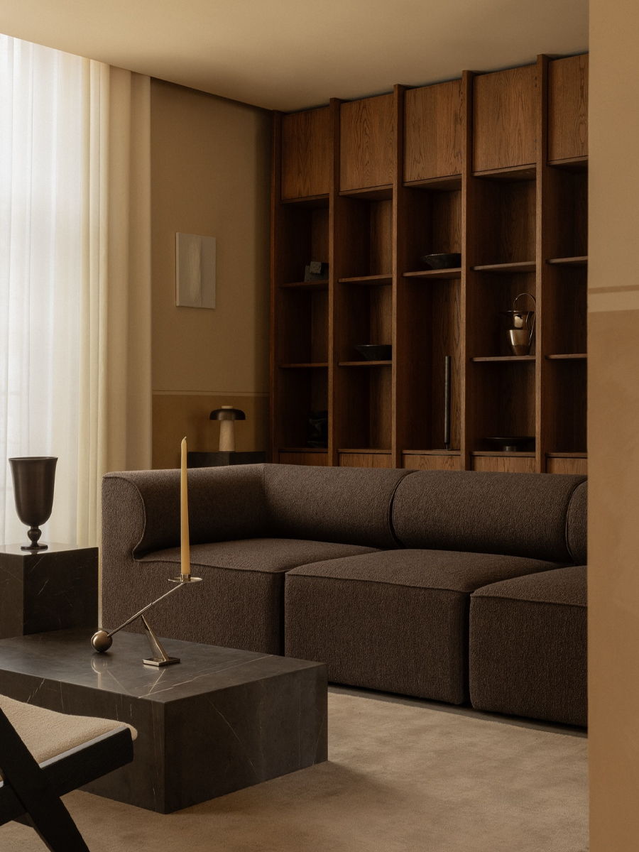 Modern living room with a brown Audo Sofa and wooden shelves.
