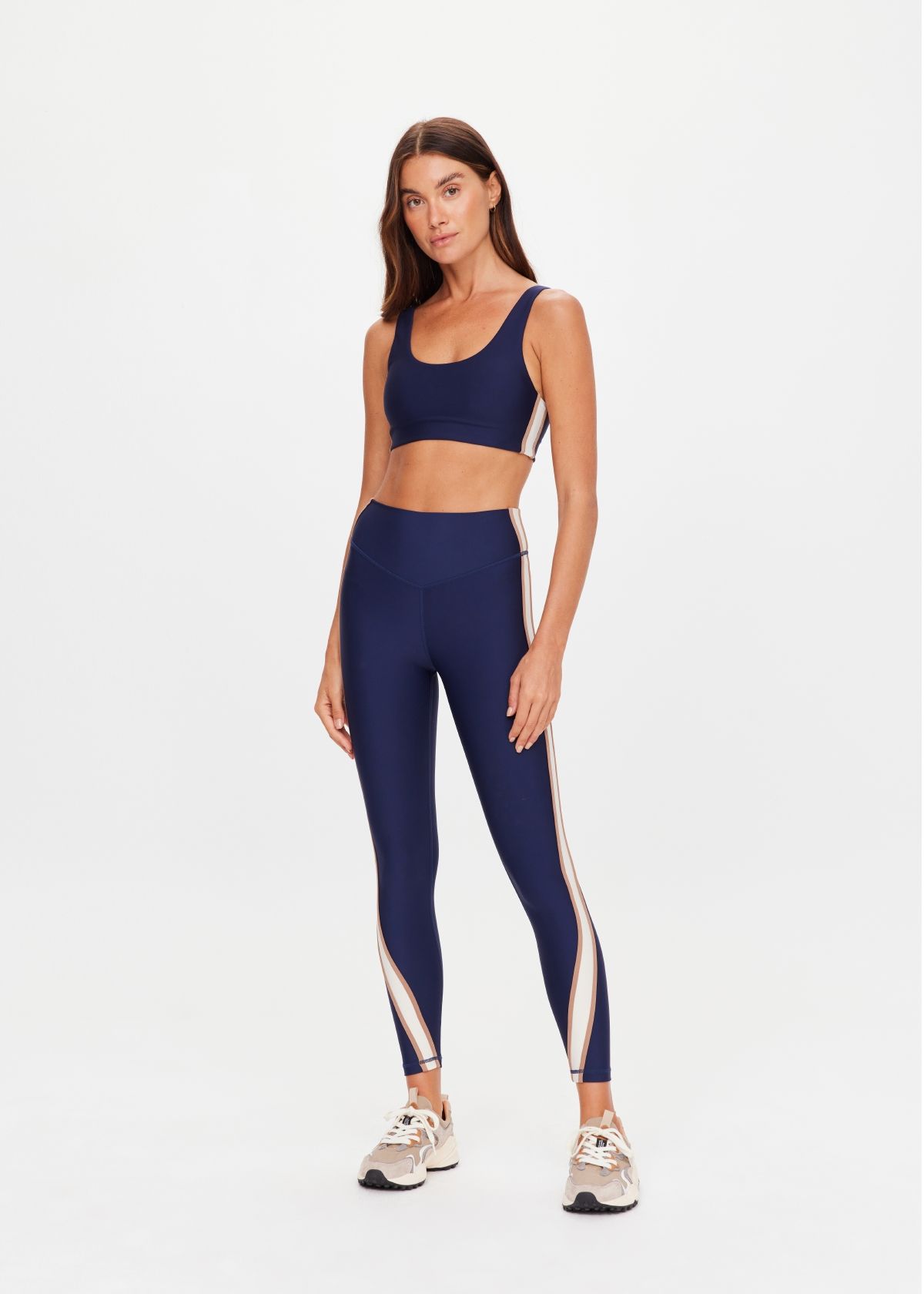 Woman in activewear posing against a plain background.