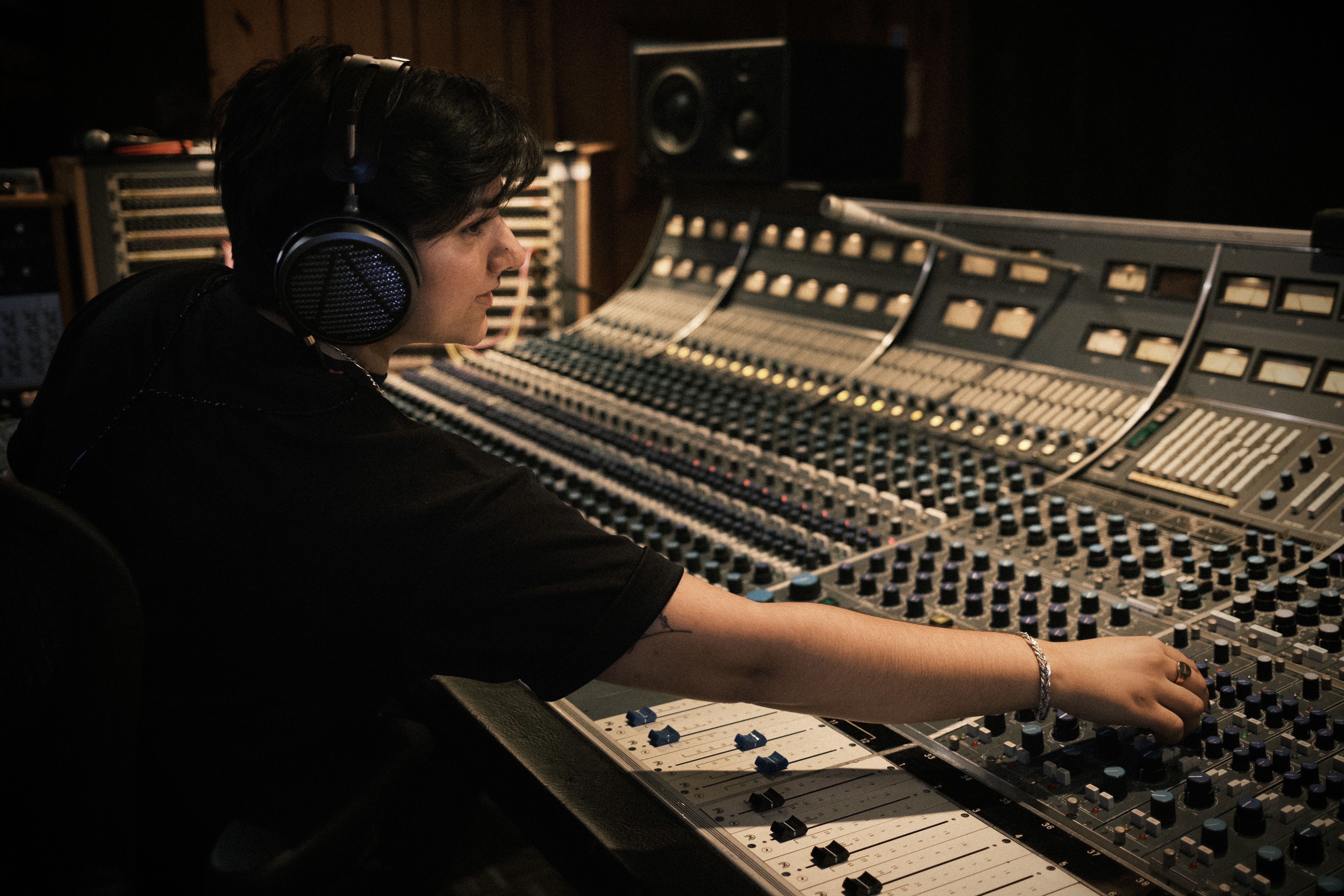 Pmisha wearing Audeze MM-500 headphones mixing in the studio