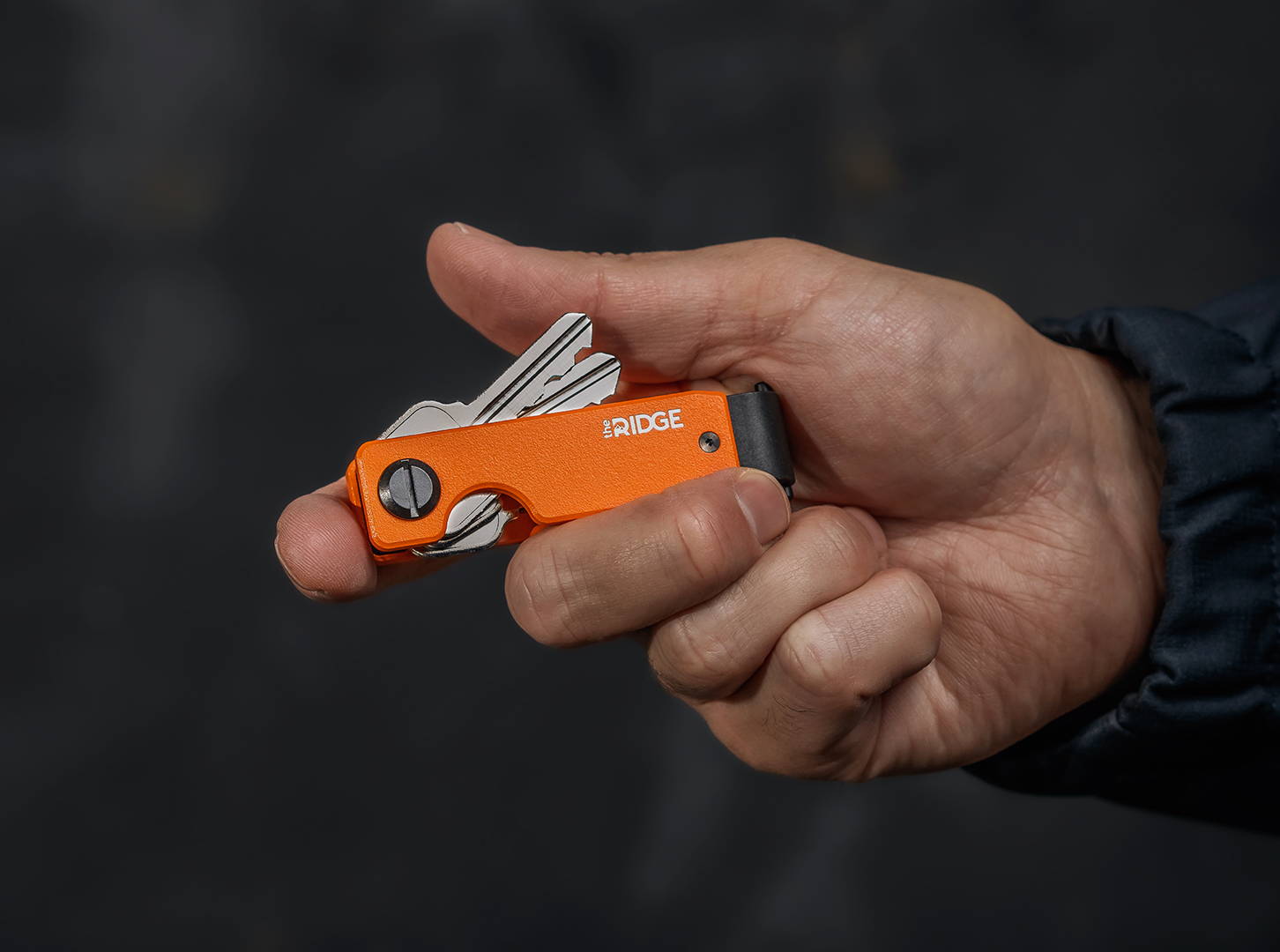 hand showing a Ridge Basecamp Orange keycase